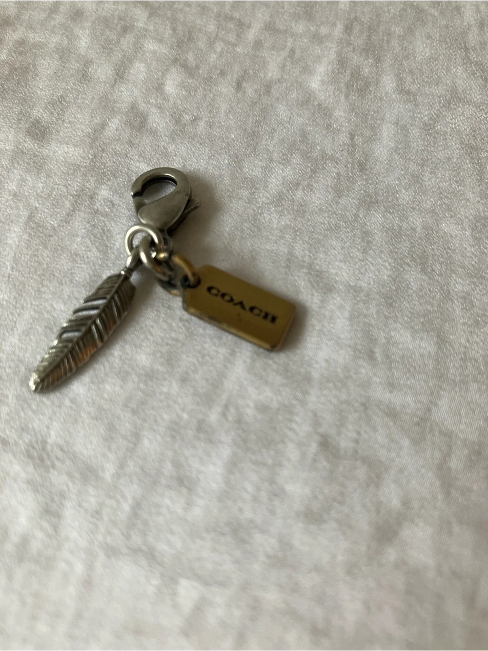Coach: Silver Tone & Gold Tone Feather Charm Keyring